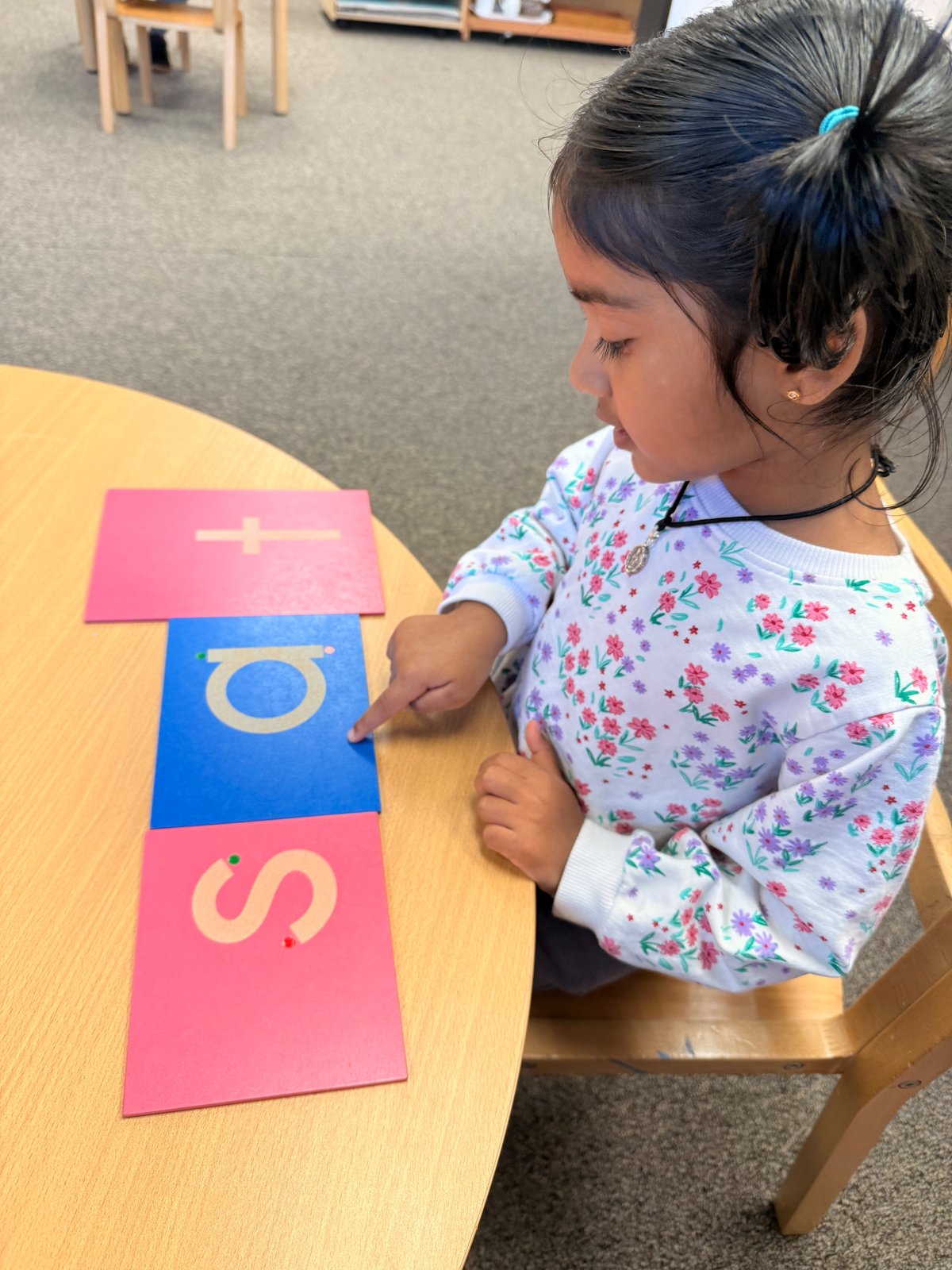 child tracing sandpaper letters