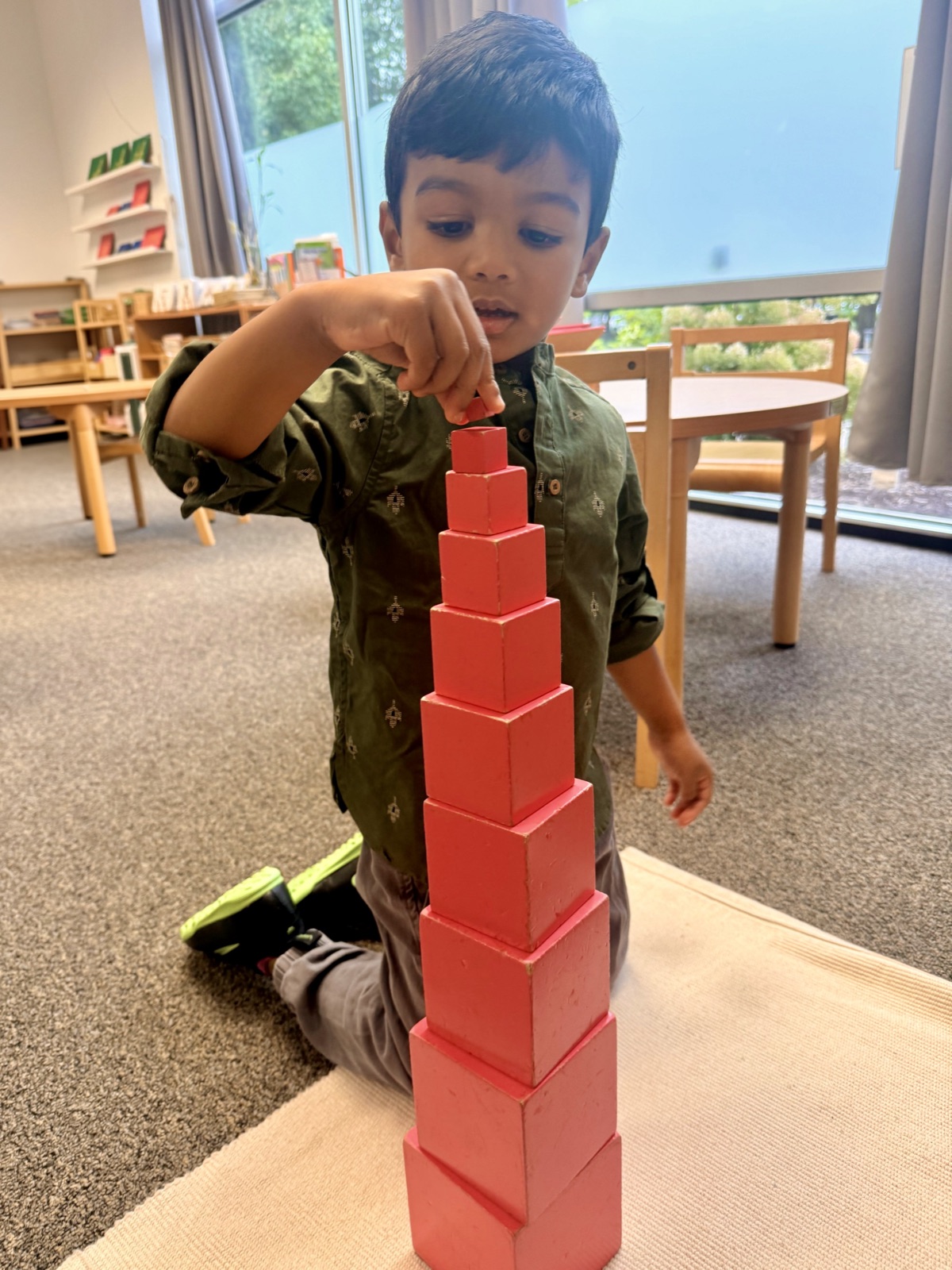 child building the Pink Tower, sensorial work